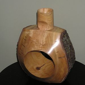 A two axis vase in cherry with a natural edge