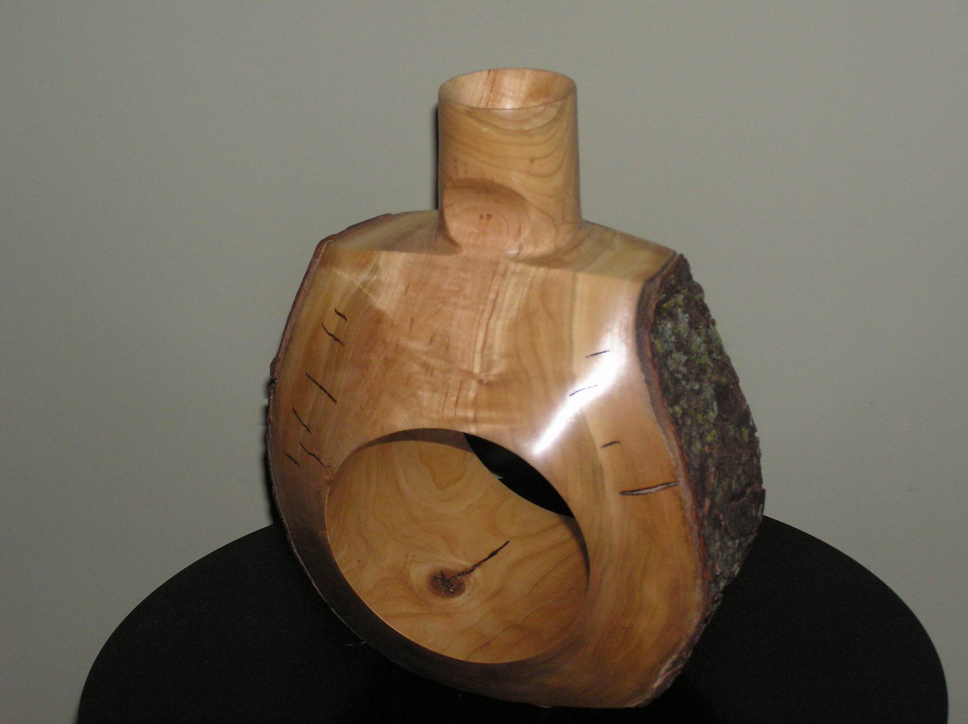 A two axis vase in cherry with a natural edge
