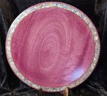 16 platter made of purpleheart wood with an abalone inlay along the rim. Platter is displayed on a plate stand with a black velvet backdrop.