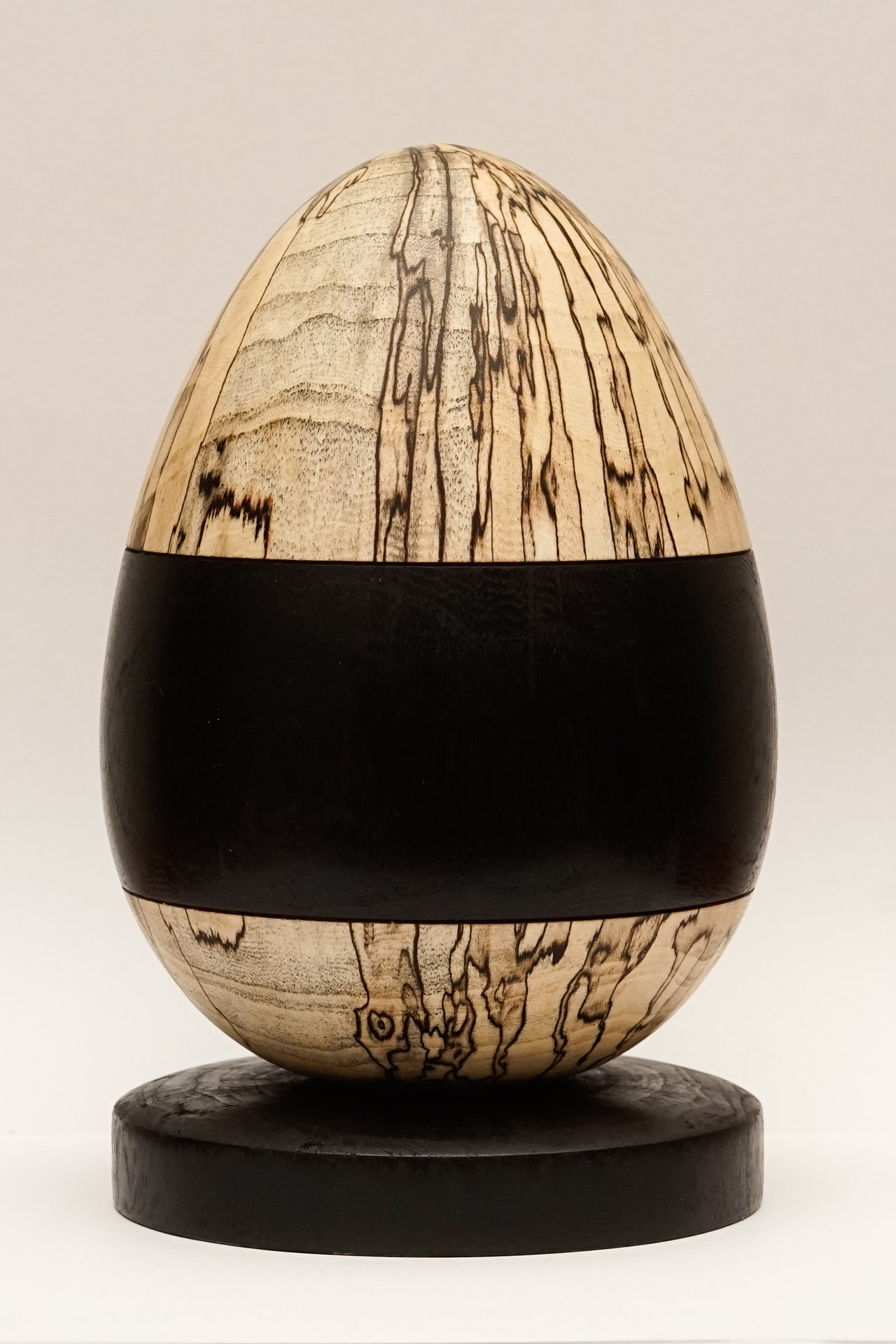 Spalted Sugarberry egg with ebonized band and ebonized Sugarberry base.